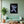 Cuadro de astronauta rockero en MDF sobre pared verde menta, con sofá verde, planta y mesa de madera